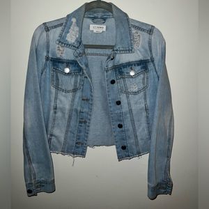 Light wash jean jacket with distressed and ripped style.